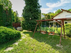 A backyard with a wooden swing set, a brick fire pit, and a stone pathway. - Stunning private villa for 8 guests with A/C, private pool, WIFI, TV, terrace and pets allowed (Balatonfüred)