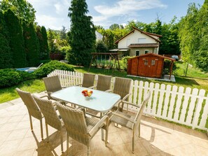 A patio with wicker furniture and a table, surrounded by a white picket fence. - Stunning private villa for 8 guests with A/C, private pool, WIFI, TV, terrace and pets allowed (Balatonfüred)