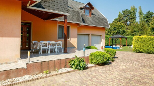 A house with a covered patio, a swimming pool, and a well-maintained garden. - Wonderful private villa for 8 guests with private pool, WIFI, TV and terrace (Balatonfüred)