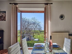 Enjoy a meal with a view of the lush garden and distant mountains from this dining area with a balcony.