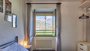Makuuhuoneessa on sänky, yöpöytä lampulla, patteri, ikkuna, josta avautuu näkymä kaupunkiin ja vuorille, sekä seinälle ripustettu naulakko.