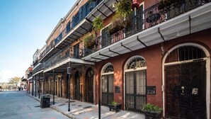 A row of historic buildings with arched windows and balconies, a sidewalk, and a street. - Luxury 2 Bed 2 Bath Condo In Bywater with Pool! (New Orleans)