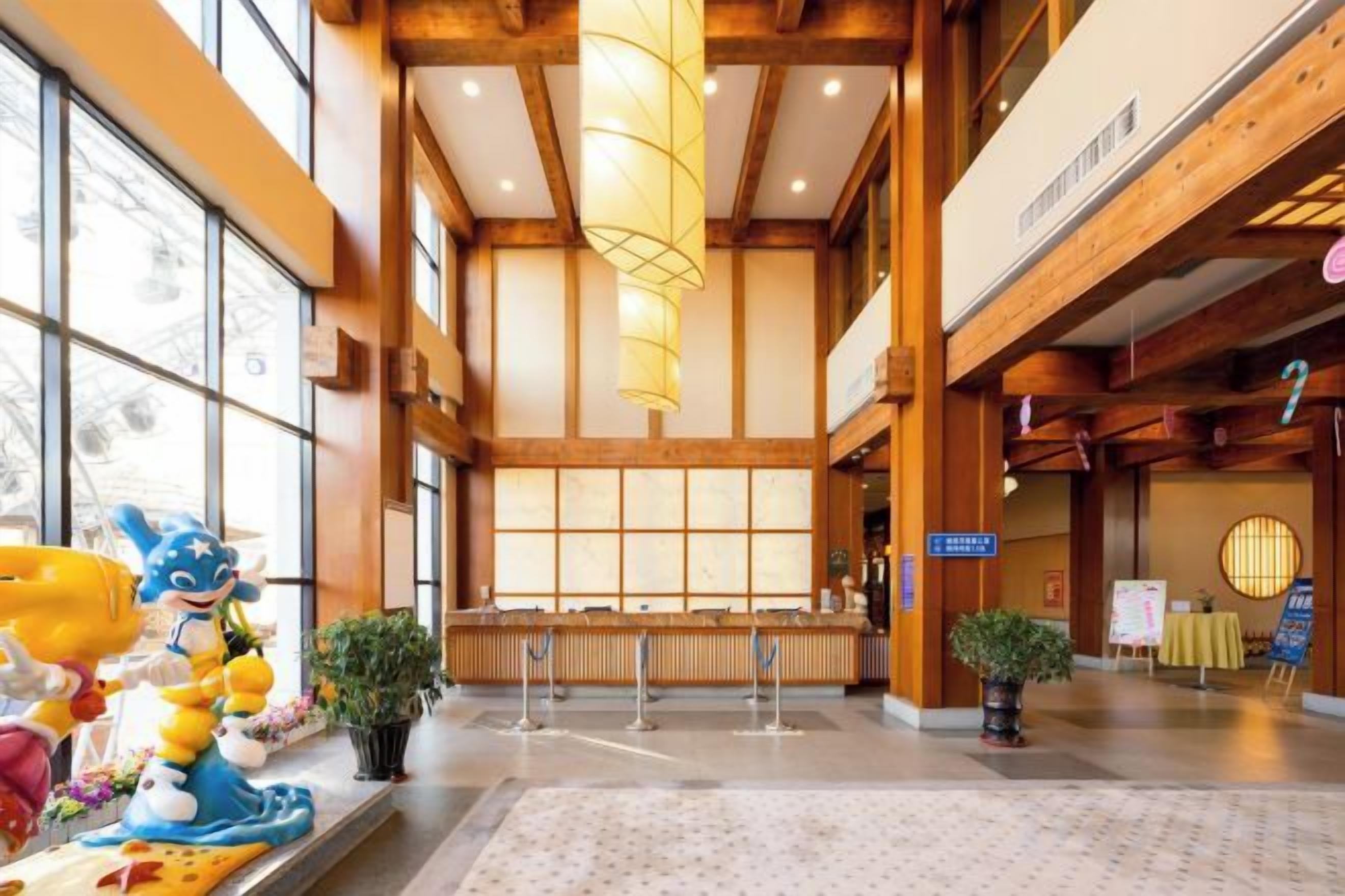 A spacious lobby with high ceilings, wooden beams, and large windows.