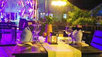 Una mesa de comedor dispuesta con cristalería, servilletas y una piña como adorno central.