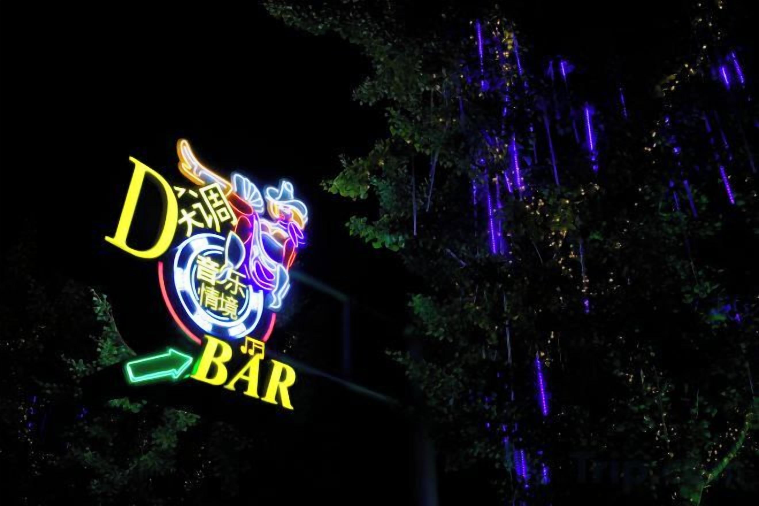 En neonskylt med texten ”D Bar” och en drakdesign.