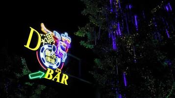 En neonskylt med texten ”D Bar” och en drakdesign.