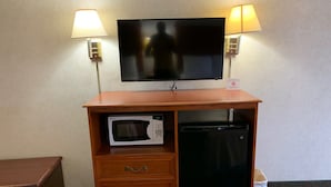 A wooden cabinet with a television, microwave, and refrigerator. - Coachman's Inn Motel (Wynne)