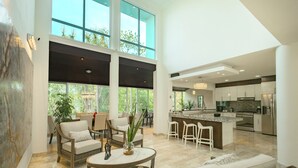 A spacious living area with a large sofa, a coffee table, and a dining area with chairs and a bar. - Puerto Morelos private House and Pool (PUERTO MORELOS)