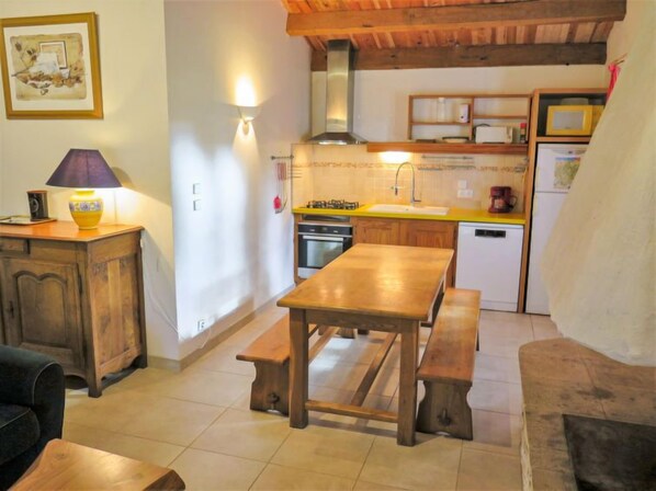A cozy kitchen with wooden furniture, a dining table, and a bench.