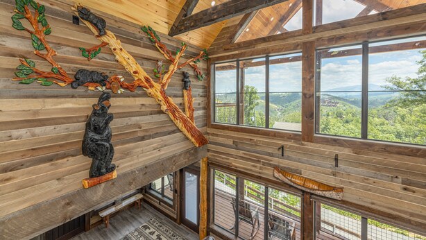 A wooden interior with large windows, a wooden ceiling, and a view of the outdoors.