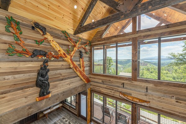 A wooden interior with large windows, a wooden ceiling, and a view of the outdoors.