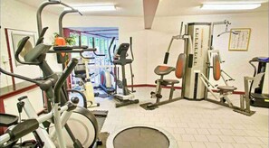 A gym with various exercise equipment, including treadmills, stationary bikes, and weight machines.