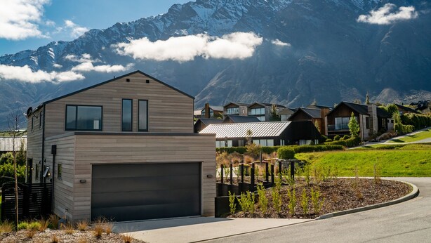 A modern two-story house with a garage, surrounded by a well-maintained garden and a mountain backdrop. - Jacks Point Family Retreat - Jacks Point Home (Queenstown)