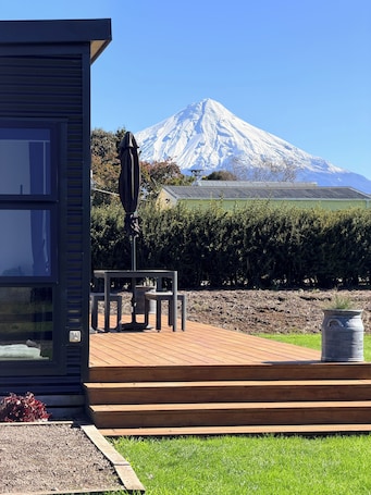 A modern building with a view of a snow-capped mountain.. Peaceful On Pembroke - 9 hole Mini Putt with stunning Mountain View’s