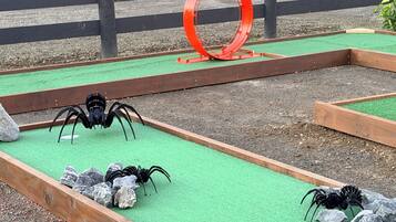 A miniature golf course with wooden bunkers and a red circular obstacle.