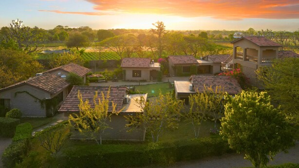 Un barrio residencial con varias casas, un pequeño jardín y vistas del atardecer.