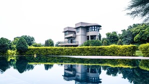 Un edificio moderno con una piscina reflectante al frente.