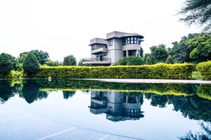Una piscina al aire libre, sombrillas, sillones reclinables de piscina