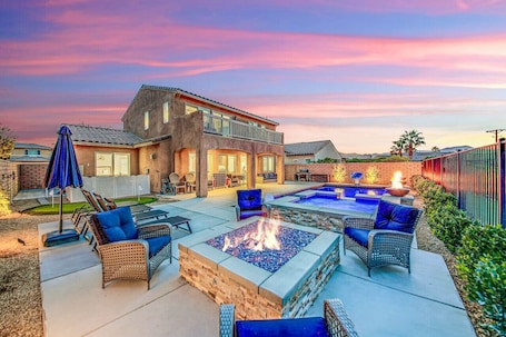 A backyard with a fire pit, outdoor furniture, and a swimming pool.