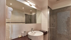 A modern bathroom with a white sink, a mirror, and a shower area with tiled walls. - Apartment in an apartment complex (Schio)