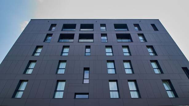 A modern building with a symmetrical facade, multiple windows, and a flat roof. - Apartment in an apartment complex (Schio)