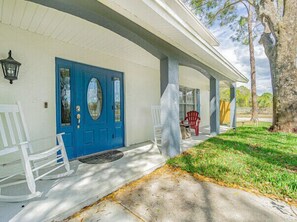 A house with a blue front door, white porch columns, and two rocking chairs. - Perfect Location Heated Pool House (Tampa)