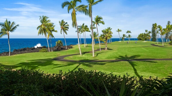 A golf course with a view of the ocean and palm trees. - 🏖️Keauhou Ocean-View Condo with Shaded Lanai & 2 King Beds | Kanaloa 1501 (Kailua Kona)