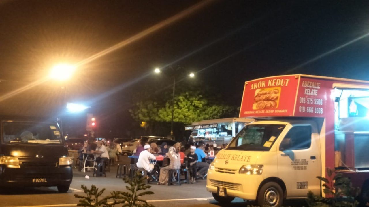 Een foodtruck met een rood en wit bord waarop 'Akok Kedut' en 'Abezalie Kelate' staan.