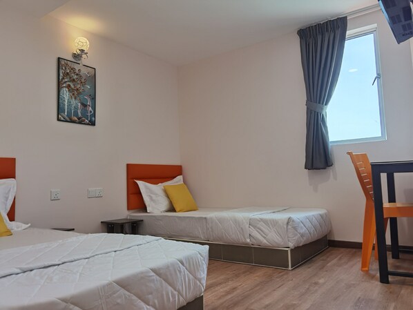 A hotel room with two beds, a desk, and a chair.