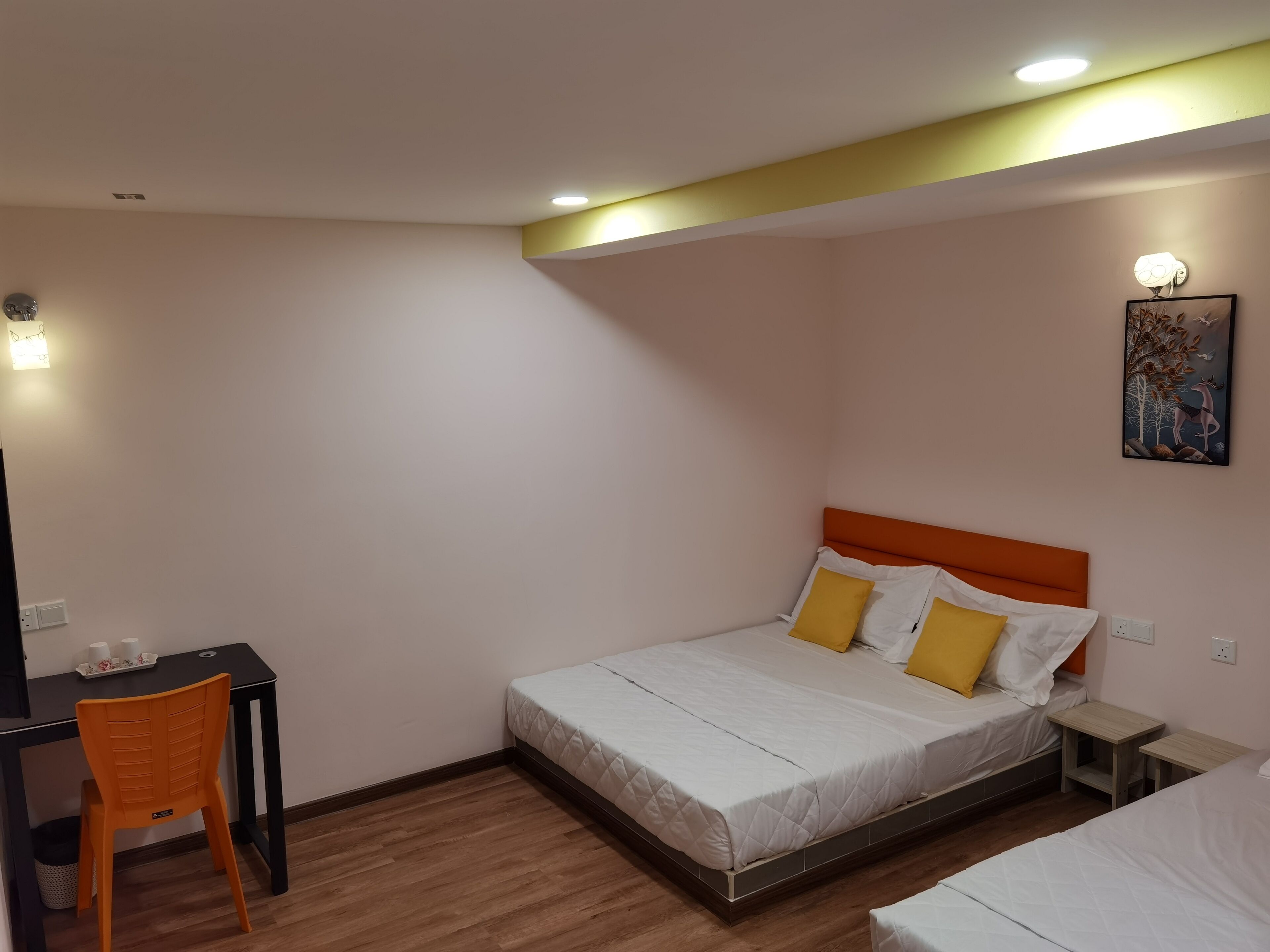 Um quarto pequeno e bem arrumado, com uma cama de solteiro, uma escrivaninha e uma cadeira.