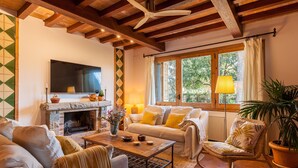 A cozy living room with a fireplace, sofa, and a television.