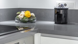 A kitchen with a glass bowl of vegetables, a black appliance, and a digital clock. - Apartment 'Casa Sydhavshytten' with Sea View, Wi-Fi and Air Conditioning (Nerja)