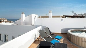A rooftop terrace with a hot tub, lounge chairs, and a view of the sea. - Holiday Apartment "Casa Chana" with Terrace, Shared Pool and Jacuzzi (Almunecar)