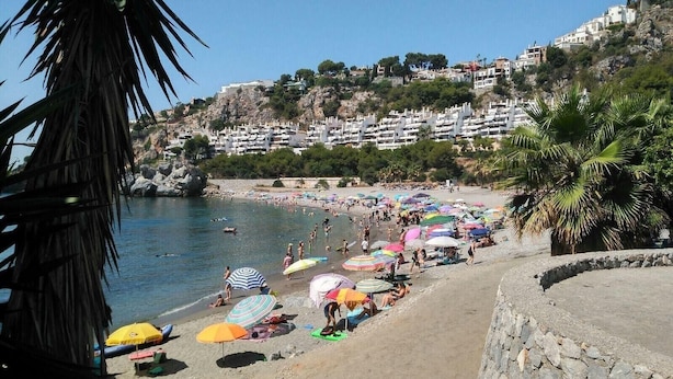 A beach with people, umbrellas, and buildings in the background. - Holiday Home 'Vista Marina' with Mountain Views, Garden and Wi-Fi (La Herradura)