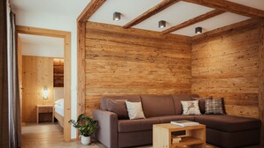 A modern log cabin interior with a brown sofa, a wooden coffee table, and a potted plant.
