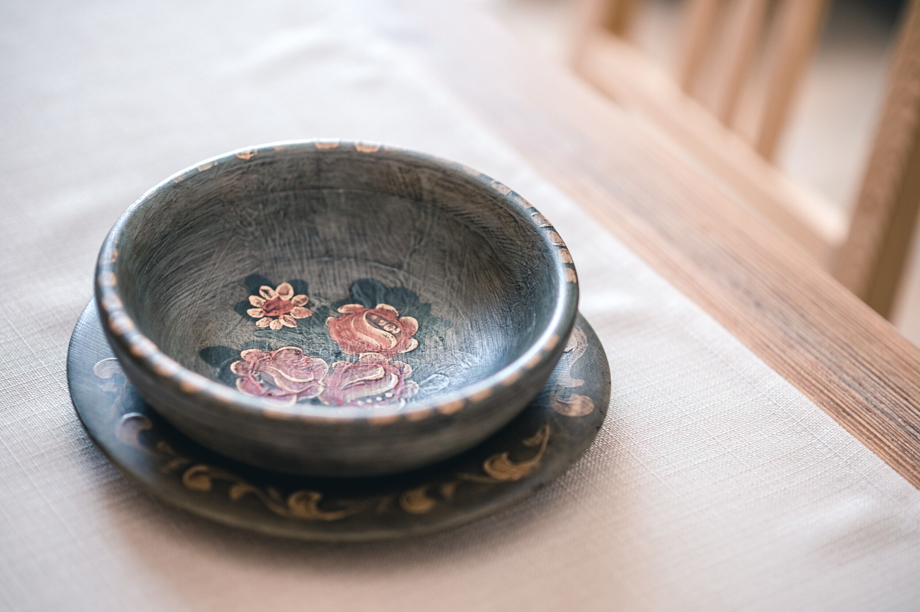 Un bol orné de motifs floraux, posé sur une nappe.