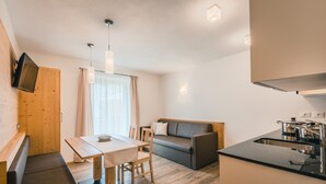 Een functionele leefruimte met kitchenette, een eethoek en een zithoek.