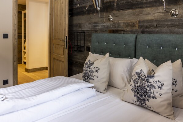 Cozy retreat with a neatly made bed, wooden headboard, and pendant light fixture.