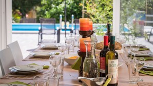 A table set for a meal with wine bottles, glasses, and a candle.