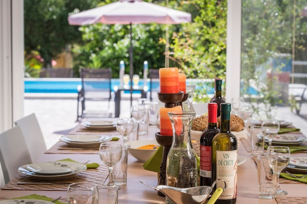 A table set for a meal with wine bottles, glasses, and a candle.