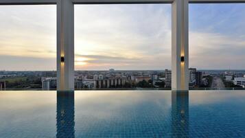 Una piscina al aire libre, sillones reclinables de piscina
