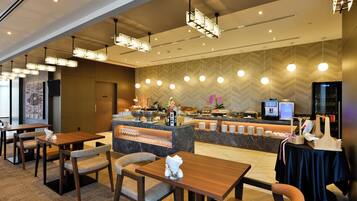 A hotel lobby with a reception desk, seating area, and a buffet.