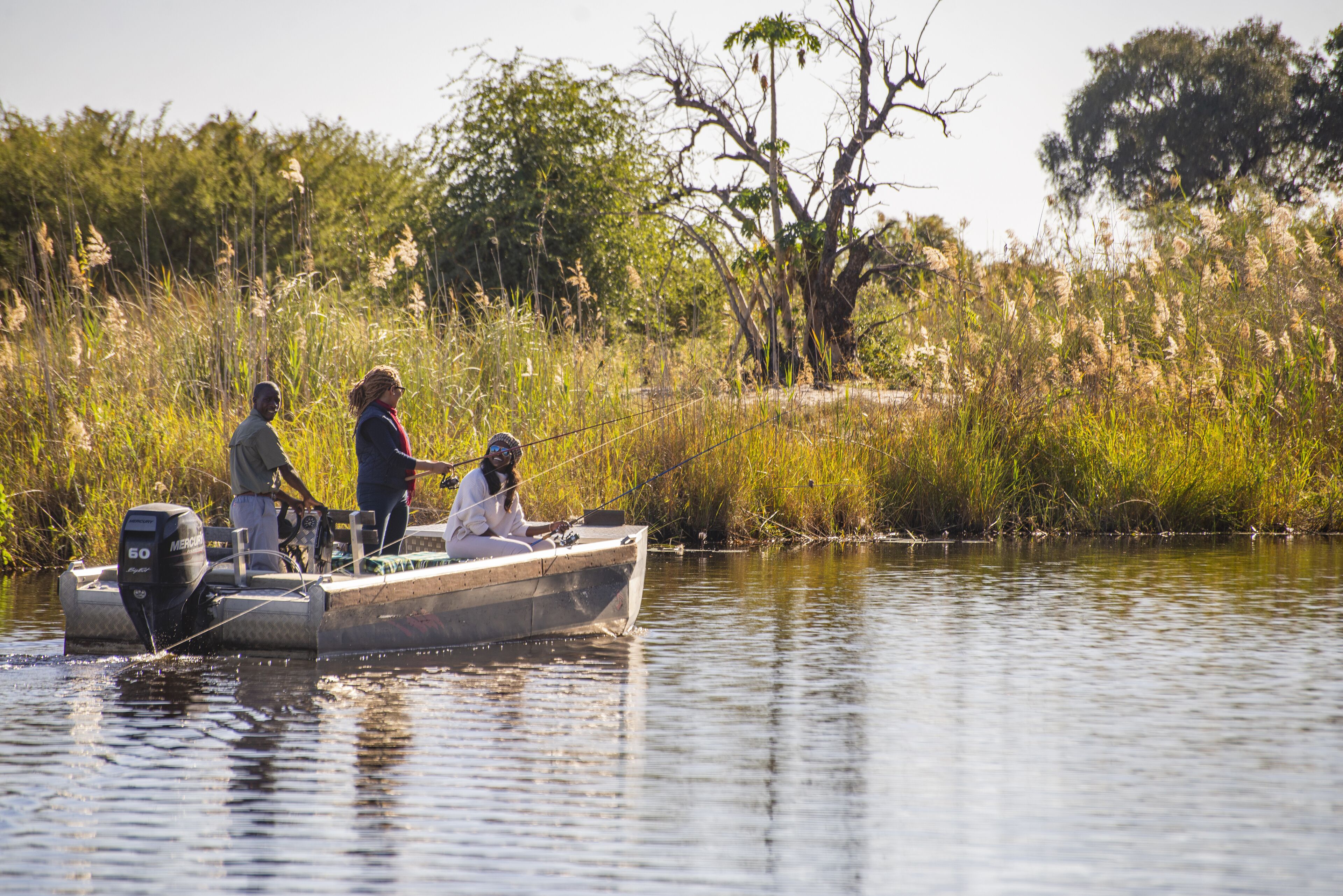 A small boat on a calm river with people on board.