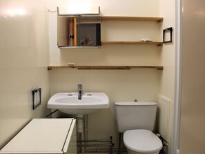 A compact bathroom with a white sink, toilet, and a small cabinet. - Cozy Studio with Alcove, Sleeps 4 - Ski-in/Ski-out, Near Shops, Stunning South-West Balcony View (Vars)