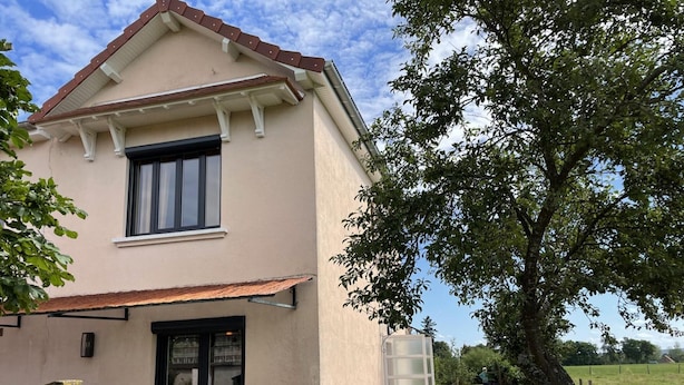 A two-story building with a beige facade and a red roof. There is a covered outdoor seating area with tables and chairs. - Renovated cottage in Pierrefitte-sur-Loire with garden and parking (Pierrefitte-sur-Loire)