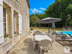 A stone building with white shutters, a pool, outdoor seating, and a grassy area. - Spacious 19th-century house with private pool, AC, park, and modern amenities in Dordogne countryside (Savignac-les-Églises)