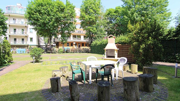 An outdoor seating area with a table and chairs, surrounded by wooden stumps.