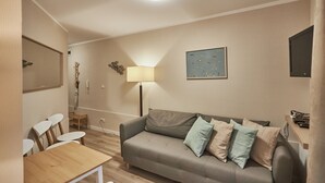 A cozy living room with a sofa, a small table, and a lamp. - Apartamenty Swinoujscie - Bursztyn (Swinoujscie)