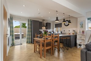 Een moderne keuken met houten meubels, een eethoek en uitzicht naar buiten.