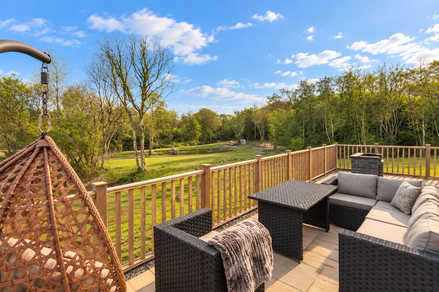 An outdoor patio with wicker furniture, a swing, and a view of a golf course.